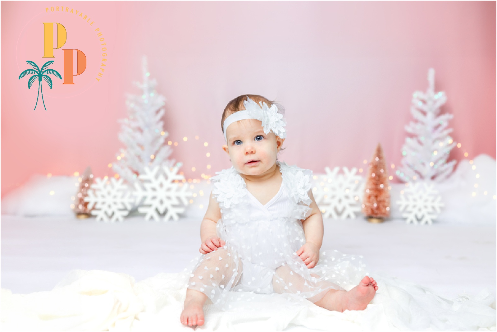 Charming images of a little snow princess's cake smash session, expertly photographed by an Orlando Cakesmash Photographer, featuring a delightful blend of pink hues and snowy magic.