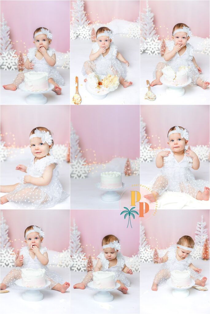 Adorable one-year-old girl joyfully exploring her first birthday cake in a Winter Wonderland-themed photoshoot by a skilled Orlando Cakesmash Photographer.