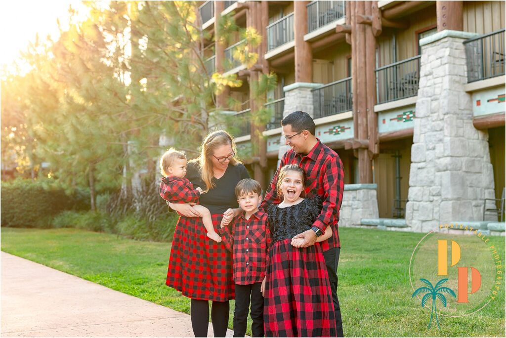 Experience the warmth and charm of a Disney Wilderness Lodge photoshoot with this heartwarming family portrait, where love and laughter meet the rustic elegance of the lodge's holiday decor.