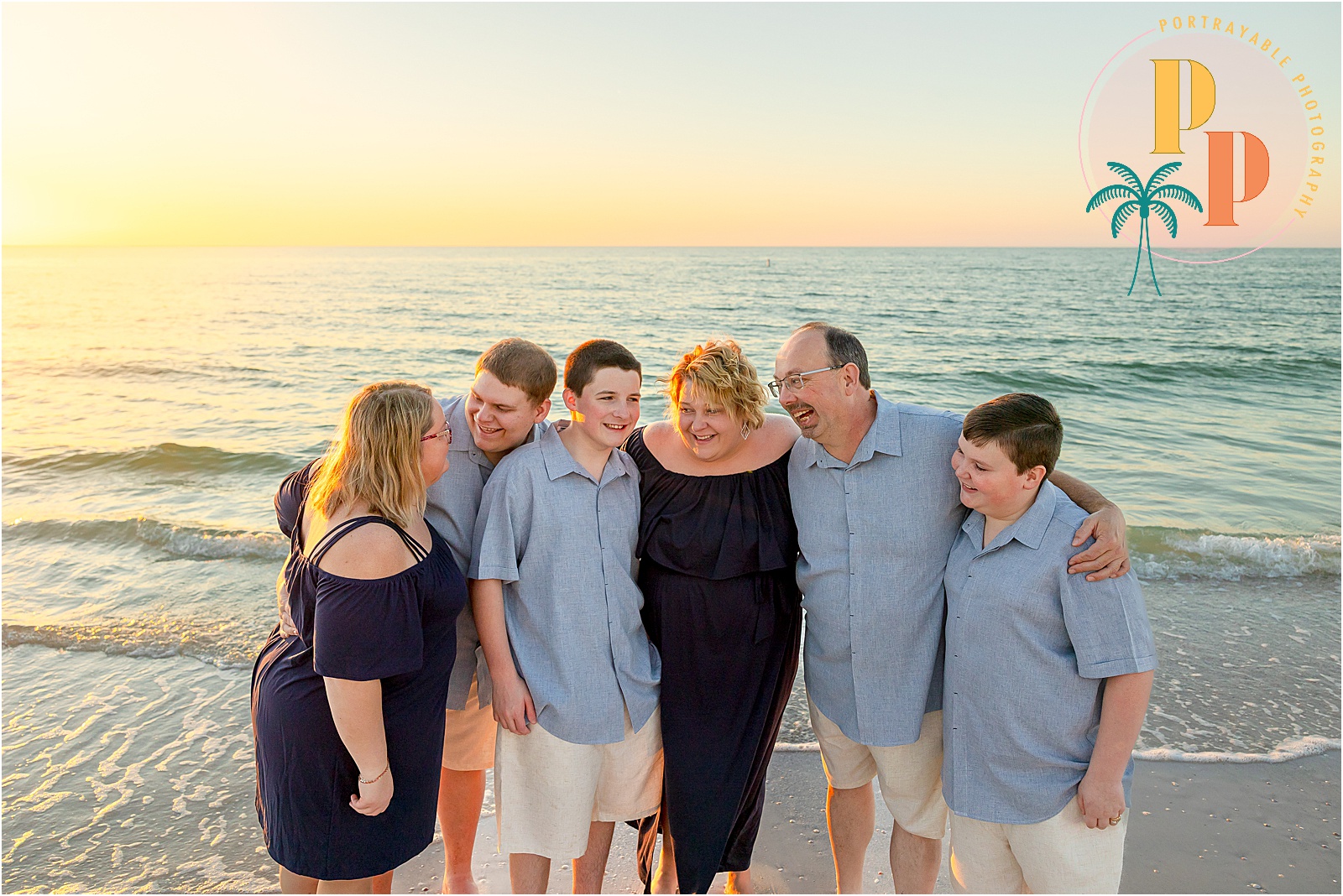 Family gathering on the beach at sunset.